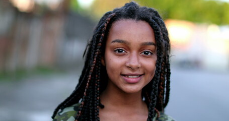 Hispanic little girl child portrait face smiling outside, black latin ethnicity