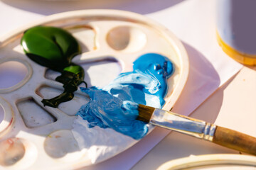 Paints and brushes on a wooden background.