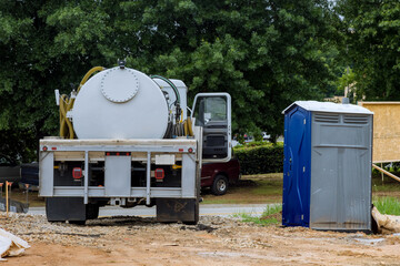 Cleaning portable restrooms with the help of a vacuum septic truck on construction site