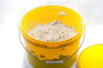 A special paste for cleaning hands from dirt as a result of working with industrial equipment and printing ink. Hand cleaner in a bucket. Selective focus.