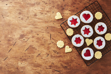 Classic Linzer Christmas Cookies with raspberry or strawberry jam on wooden table