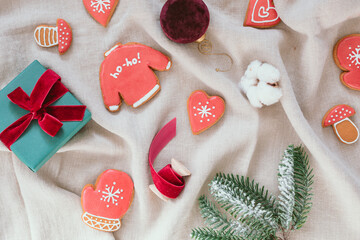 Festive composition of Christmas gingerbread cookies, wrapped gift box, decorations. Flat lay, top view. 