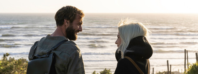 Horizontal banner with romantic happy couple in love standing at the wild beach in front of the sea...