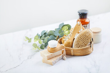 Two bars of soap, wash and massage brushes, and rolled towel. Hy