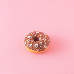 Creative aesthetic Halloween concept made of donut and artificial eyes. Minimal spooky food and dessert concept on a pink background.