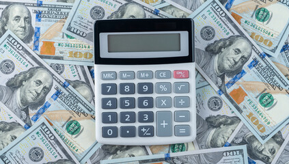 calculator on background of us dollars banknotes. Money counting, crowdfunding, business plan, accounting and audit concept. Calculator ready for auditing. top view