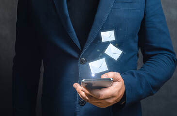 Man hands using cellphone with flying envelopes. close up businessman hand touchscreen on...