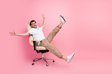 Full length photo of playful manager guy relax after work ride fast chair isolated on pastel color...