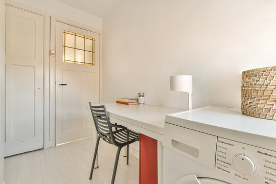 Modern workplace with desk chair and washing machine