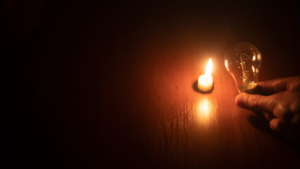 light bulb and candle on black background