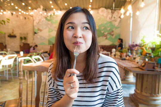 Asian woman eat sweet food in art restaurant