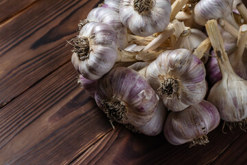 Knitted bundle of garlic isolated on wooden background