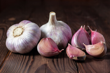 Garlic cloves on wooden table. Fresh peeled garlics and bulbs.
