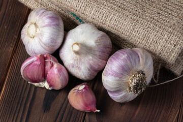 Garlic bulb on wooden background and sackcloth. Close up