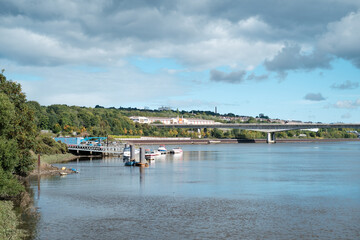 Fototapeta premium Newcastle UK: 24th Sept 2022 Newburn Riverside at the River Tyne on Hadrians Cycleway - Route 72. Waves on a windy day with the A1 motorway bridge and BandQ in the background