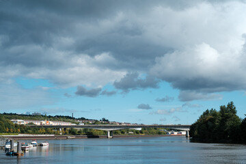Obraz premium Newcastle UK: 24th Sept 2022 Newburn Riverside at the River Tyne on Hadrians Cycleway - Route 72. Waves on a windy day with the A1 motorway bridge and BandQ in the background