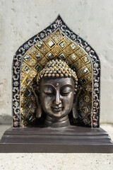 Buddha statue near house in front of wall.