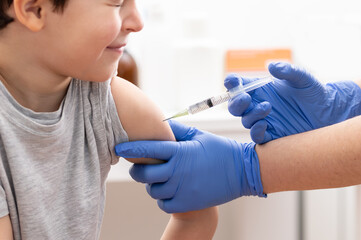 Photo of a boy receiving a vaccine in a hospital and closing his eyes