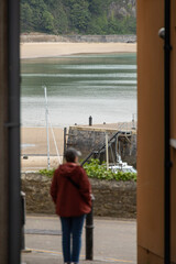 woman standing in an alleyway by the beach