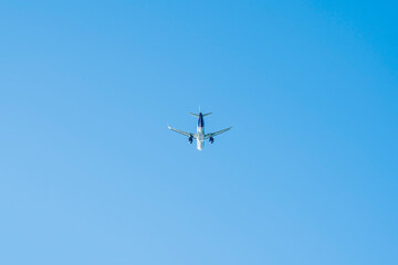 the plane is flying against the blue sky