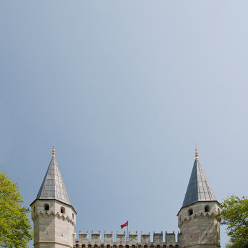The Harem at the Topkapi Palace in Istanbul, a 15th century building, two pointed towers and battlements against a clear sky.