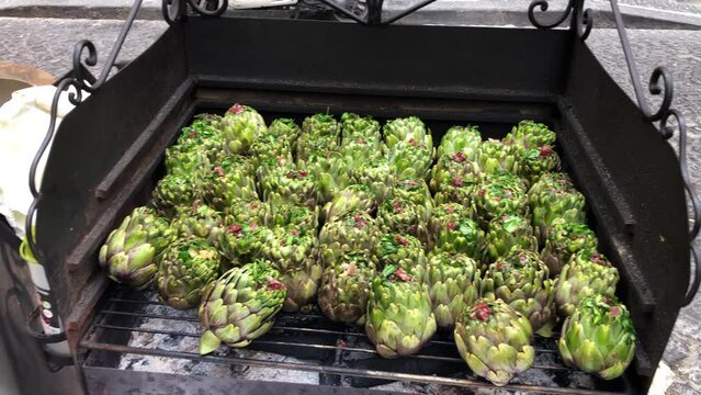 Naples typical street food, roasted artichokes on grill in street of center Naples, Italy