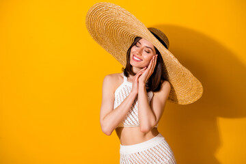 Photo of shiny adorable lady wear white outfit hat arms hands cheek cheekbone closed eyes isolated yellow color background