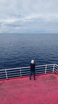 Man on a ferry looks at the sea and the horizon while traveling. Lonely man watches the sea voyage from the ship. loneliness and melancholy during a sea crossing