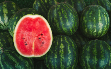 Several large sweet green watermelons and cut watermelons, young green watermelons,