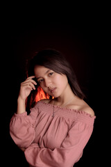 Young Asian woman wearing a pink crop top. Stand and take half body on black background. Express emotions.