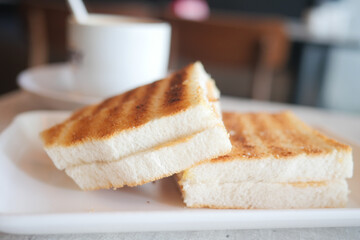top view of peanut butter and a bread on plate on black background 