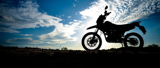 Beautiful evening motocross motorcycle silhouette on the mountain