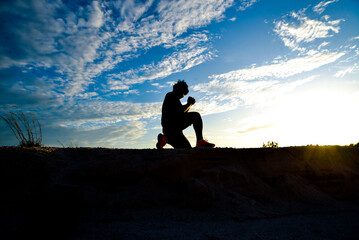 Silhouette, a lonely, heartbroken, disappointed man, praying to God for all to be better.