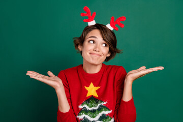 Photo of unsure funny girl dressed pullover deer hair band shrugging shoulders looking empty space...