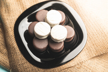 Obraz na płótnie Canvas Alfajor artesanal de chocolate blanco y chocolate negro relleno de dulce de lecha