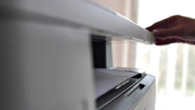 A girl office worker makes a photocopy of documents using a photocopier. The director's secretary is doing his job. Clerk in the office during work with copier.