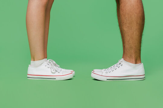 Cropped Close Up Side View Photo Shot Caucasian Young Couple Two Friends Family Man Woman Wearing Basic Sneakers Shoes Together Isolated On Pastel Plain Light Green Color Background Studio Portrait.