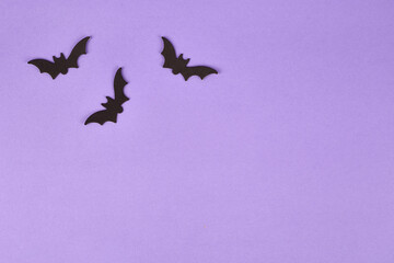 Halloween decorations, pumpkins, on violet background. Halloween party greeting card. Copy space. Flat lay, top view, overhead.