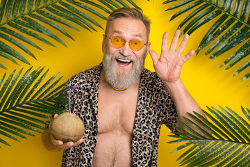 Photo portrait of attractive granddad wave hand hold coconut cocktail wear trendy leopard print...