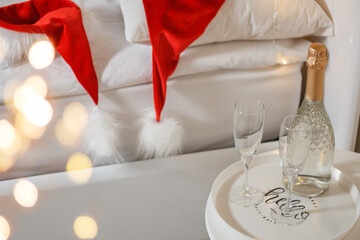 Two glasses and a bottle of champagne in a hotel room with Christmas decor. The concept of...