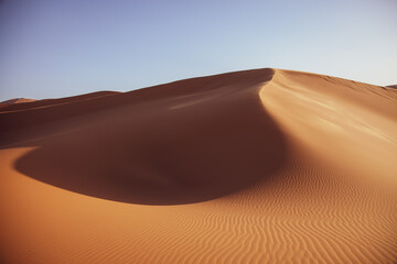 Fototapeta na wymiar Desierto sol y sombra sobre cielo azul. Desert sun and shadow on blue sky.