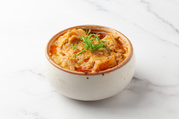 Close-up of Paneer Butter Masala or Cheese Cottage Curry garnished with fresh green coriander leaves  in serving a bowl or pan,