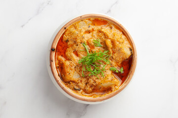 Close-up of Paneer Butter Masala or Cheese Cottage Curry garnished with fresh green coriander leaves  in serving a bowl or pan,