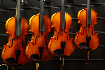 Various violin models hang in the shop for sale.