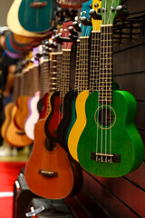 Various guitars of different models hang in the store for sale.