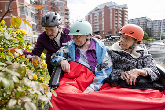 Volunteer and elderly women friends in trishaw looking at flowers