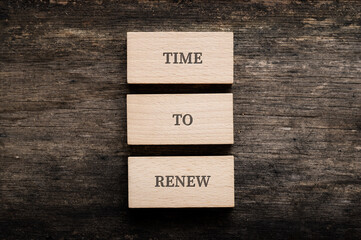 Time to renew sign spelled on three stacked wooden blocks