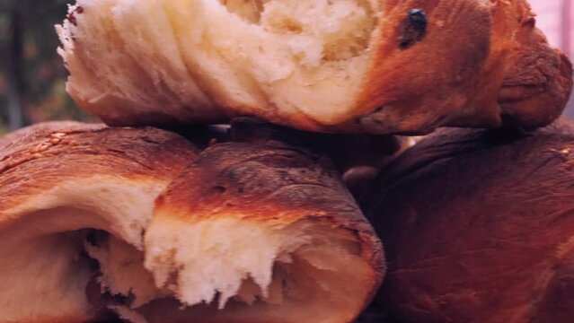 Freshly baked fried challah with raisins is rotated in a circle on a wooden board. Medium plan