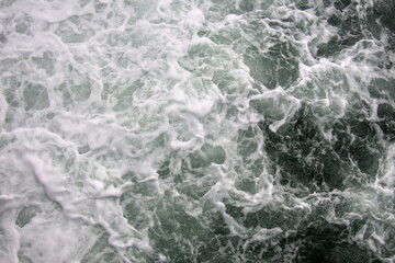 Breaking waves of black sea close up as dark cold rough natural abstract texture backdrop background wallpaper, wild nature, surface of ocean water wave splash and foam