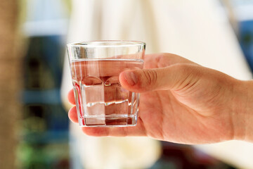 Close-up view of glass of water in male hand